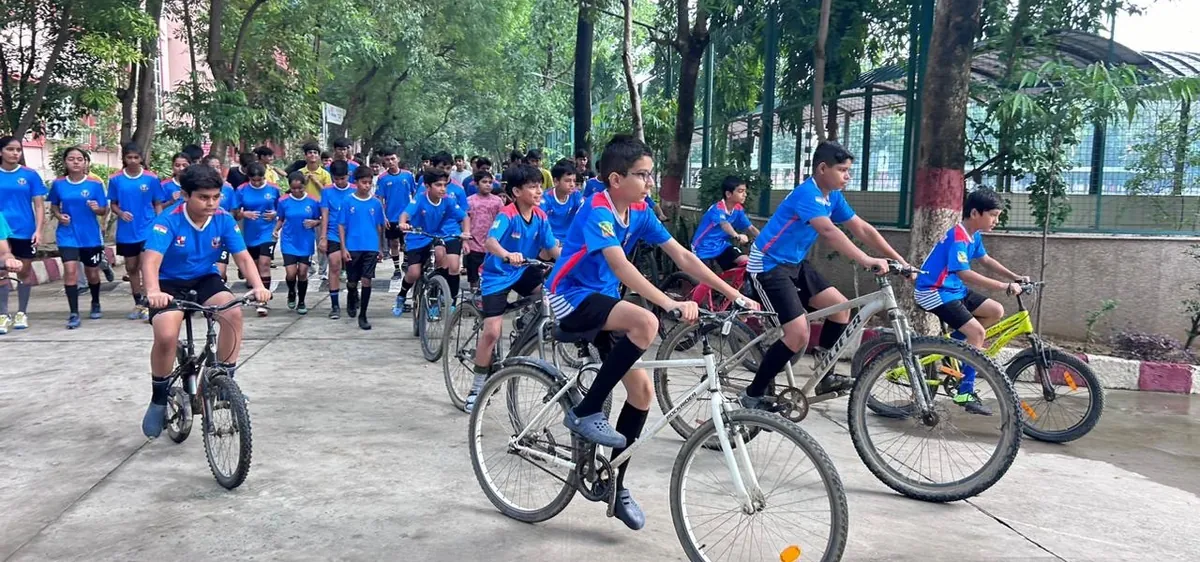 K-IIT students cycling along a tree-lined campus path